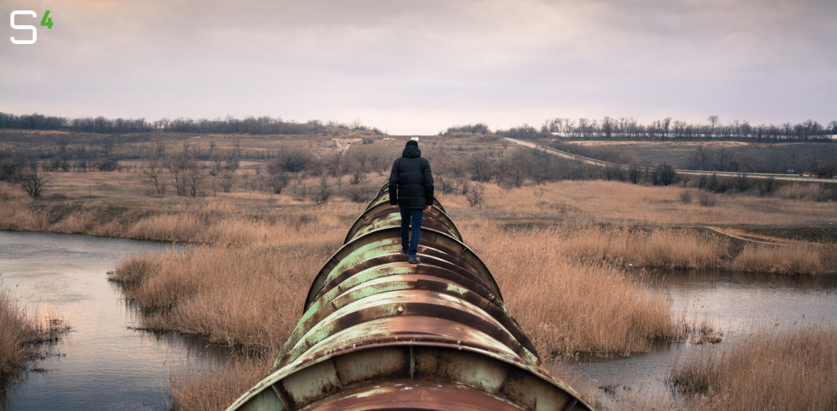 Man walking on oil pipeline